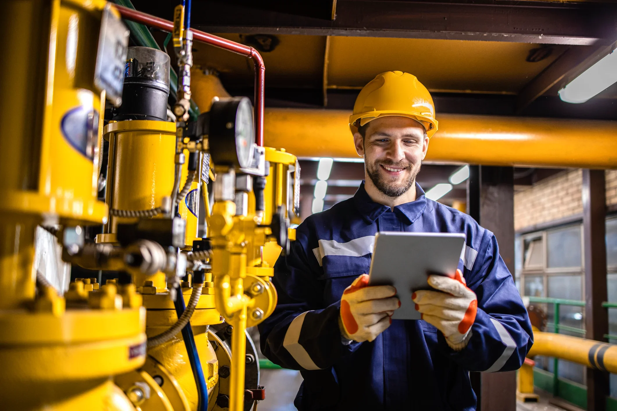 Service technician using a tablet in an industrial facility